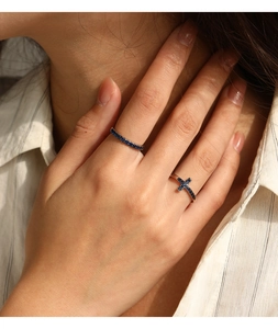 Gros plan d'un ensemble de bagues en argent S925 avec croix bleue et zircon