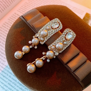 Dettaglio di orecchini pendenti vintage francesi con perle e strass su scatola regalo