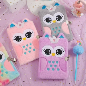 Detailed close-up of plush owl notebooks with sequins and matching unicorn pens