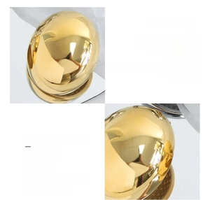 Macro detail of high-polish 18K gold plated oval earrings made of surgical titanium steel