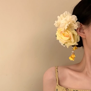 Detailed shot of fabric rose hair clip with pearl tassels for elegant floral hairstyles
