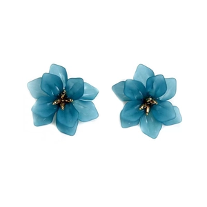 Detail view of blue acrylic flower earrings with gold pistils and petal textures