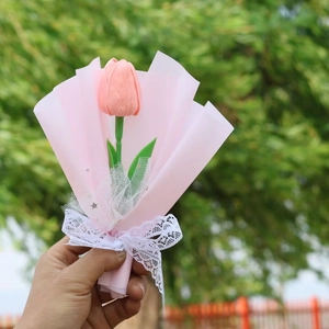 Close-up of a pink artificial tulip bouquet wrapped in delicate lace and soft pink paper