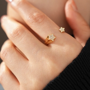 Détail d'une bague ajustable plaquée or 18k avec étoiles en zircone portée au doigt
