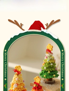 Detail of handcrafted crochet Christmas trees with colorful pom-poms and wooden base