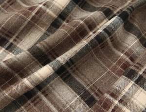 Gros plan sur la texture du tissu à carreaux marron et beige montrant le tissage détaillé