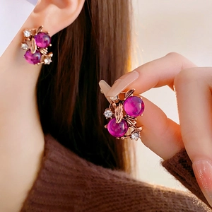Macro shot of vintage style earrings with purple gemstones and rhinestone accents