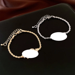 Macro detail of gold and silver twisted chain bracelets with customizable blank nameplates