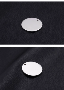 Detail view of smooth silver stainless steel round disc charm showing thickness and texture