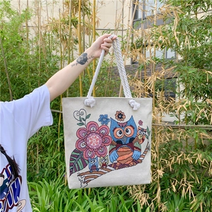Large bohemian canvas tote bag featuring vibrant floral embroidery and woven handles