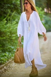 Detailed macro view of white cotton linen maxi dress with button-up V-neck and puff sleeves