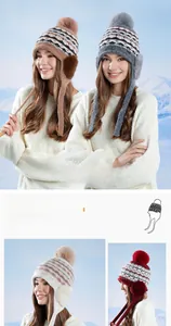 Détail du bonnet en grosse maille avec pompon en fourrure et cache-oreilles doublés