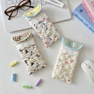 Quilted fabric soft eyewear pouches with lace trim and heart buttons on white desk