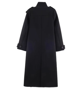 Detail view of the back of a long black coat featuring epaulettes and belted cuffs