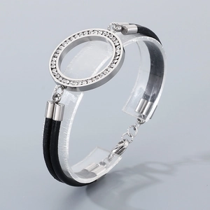 Detail of double-layer black leather bracelet with crystal encrusted round charm