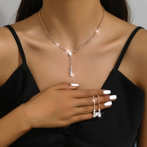 Detail of rose gold jewelry set with Y-shaped necklace and drop earrings on a model