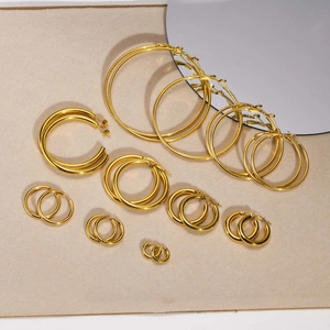 Flat lay of multiple sizes of 18k gold-plated stainless steel hoop earrings with high polish