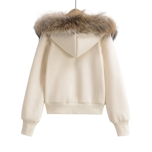 Detail view of the plush detachable fur trim on a beige hooded winter jacket