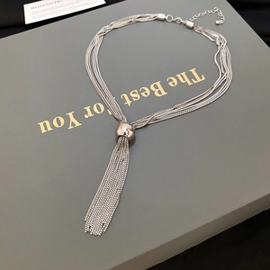 Dettaglio della collana a catena multipla argento con sfera lucida e nappa a frange lunghe