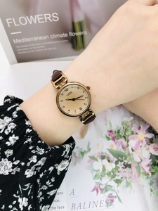Close-up of GEDI vintage small round watch with brown leather strap on female wrist