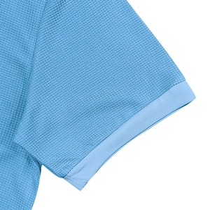 Close-up of sky blue waffle knit texture and ribbed cuff detail on men's polo shirt