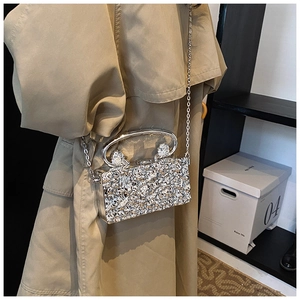 Detail of silver acrylic evening bag with ice-crack texture and knot metal handle