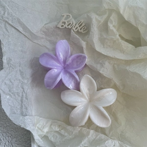 Detailed close-up of purple and cream floral hair claws with elegant marble texture