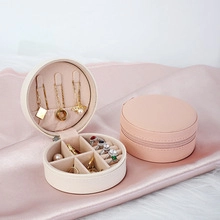 Macro view of portable round PU leather jewelry box showing interior necklace hooks and slots