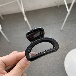 Detail shot of a glossy black hollow square hair claw clip for high ponytail styling