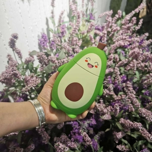 Close-up of cute avocado silicone earphone case with a smiling face and brown seed detail