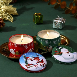 Close-up of two decorative 4.4oz Christmas scented candle tin jars with festive patterns