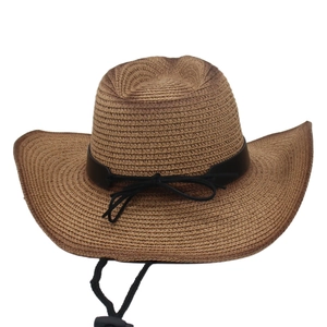 Close-up of brown straw cowboy hat with black leather strap and adjustable chin cord