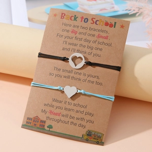 Dettaglio di braccialetti a cuore su biglietto Back to School per madre e figlia in acciaio