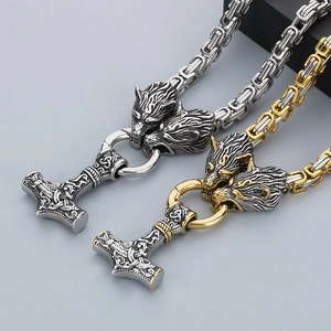 Macro view of Viking Mjolnir necklaces in silver and gold-tone with wolf heads