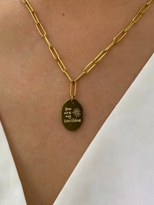 Détail du collier chaîne trombone doré avec pendentif soleil gravé You Are My Sunshine