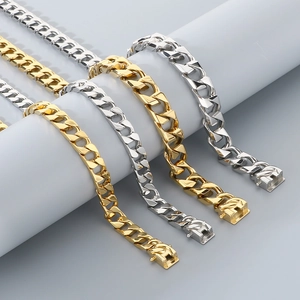 Detailed view of gold and silver cuban link chains displayed on a round grey stand