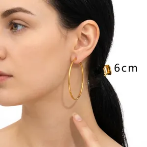Detail showing 6cm large gold hoop earrings on model highlighting size and elegant finish