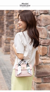 Detail of pink crossbody bag with gold chain, monogram pattern and silk scarf handle