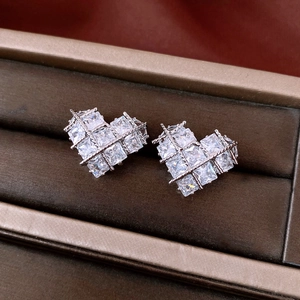 Close-up of heart stud earrings featuring princess cut zircon stones in a grid setting