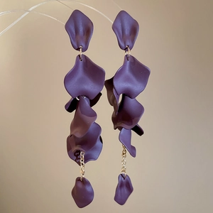 Detailed view of layered deep purple matte petals and golden tassels on drop earrings