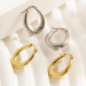 Modern twisted drop hoop earrings in gold and silver finish with textured steel surface