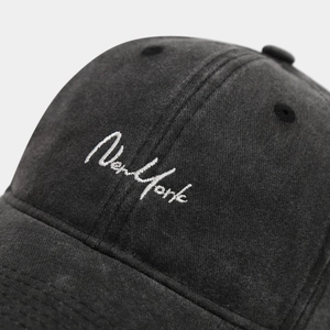 Gros plan sur la broderie New York blanche sur une casquette de baseball en coton délavé gris