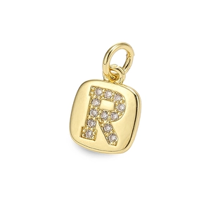 Detailed view of a gold square pendant with an R-shaped cubic zirconia inlay