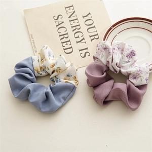 Detailed close-up of floral and solid patchwork fabric scrunchies in soft lavender and blue