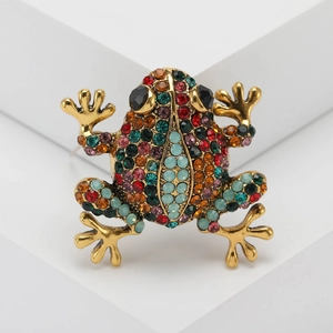 Macro shot of vintage frog brooch with colorful rhinestones on gold-plated metal
