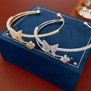 Detail view of double-layer butterfly and clover open bracelets with micro-pave zircons