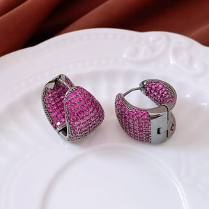 Macro shot of asymmetric drop earrings with pink zircon pavé on gunmetal finish