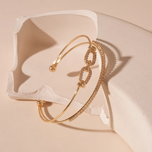 Detail of gold double-layer bangle featuring sparkling zircon stones and chain link design