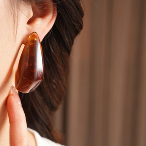 Macro detail of amber resin irregular geometric earring with translucent texture