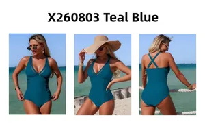 Detailed view of teal blue one-piece swimsuit with mesh panels and side ruching details